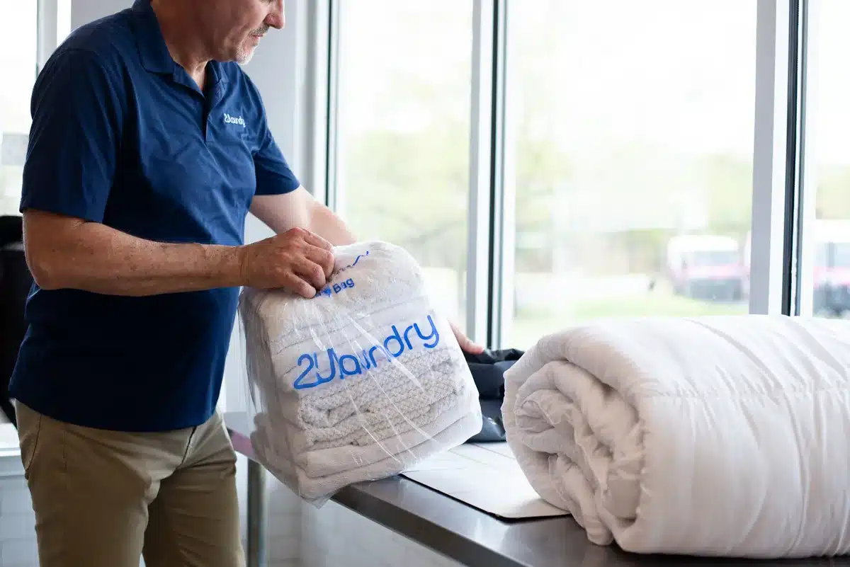 2ULaundry employee handling folded commercial linens